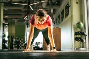young woman doing pushups after taking the best athletic performance supplements